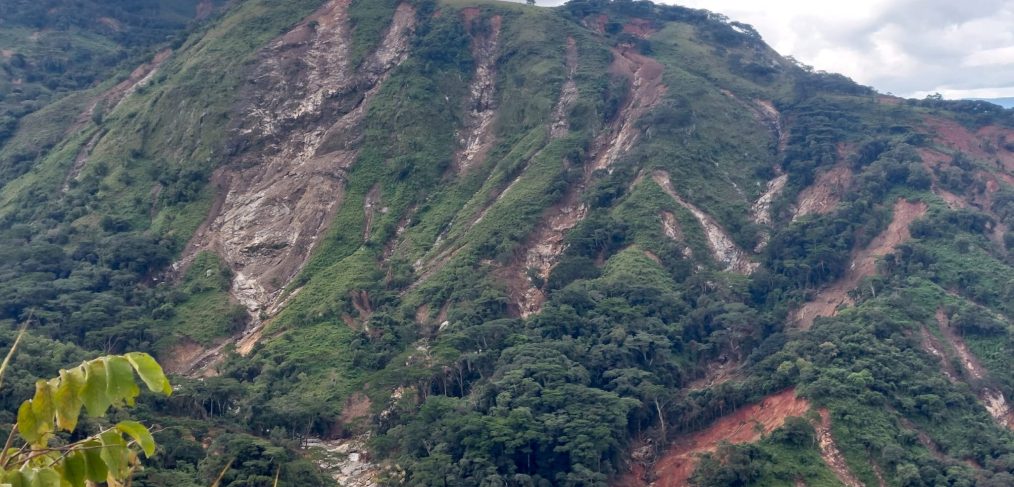 Green hill with deep gullies created by heavy rainfall.