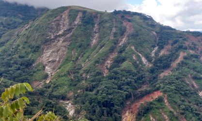 Green hill with deep gullies created by heavy rainfall.