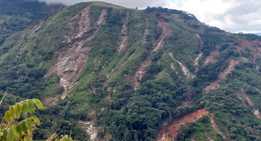 Green hill with deep gullies created by heavy rainfall.