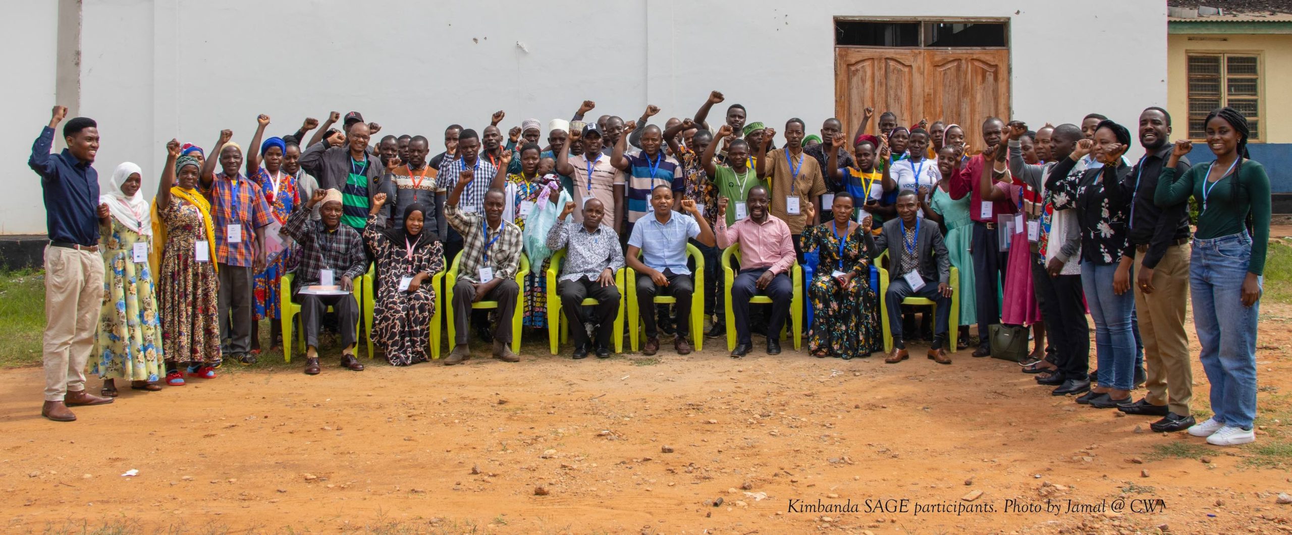 A group of around 60 people smiling at the camera.