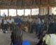 A group of people sitting in a circular meeting building.