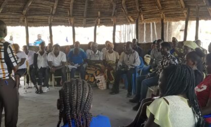 A group of people sitting in a circular meeting building.