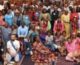 Around 50 people in a meeting room pose for a group photograph.