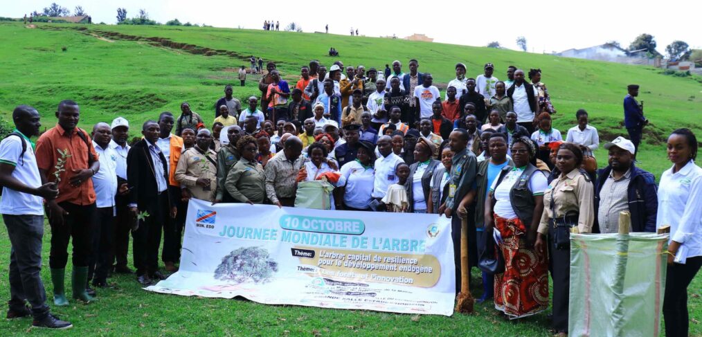 A crowd poses on a green hillside.