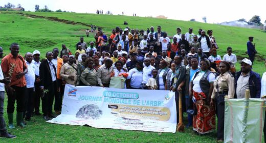 A crowd poses on a green hillside.