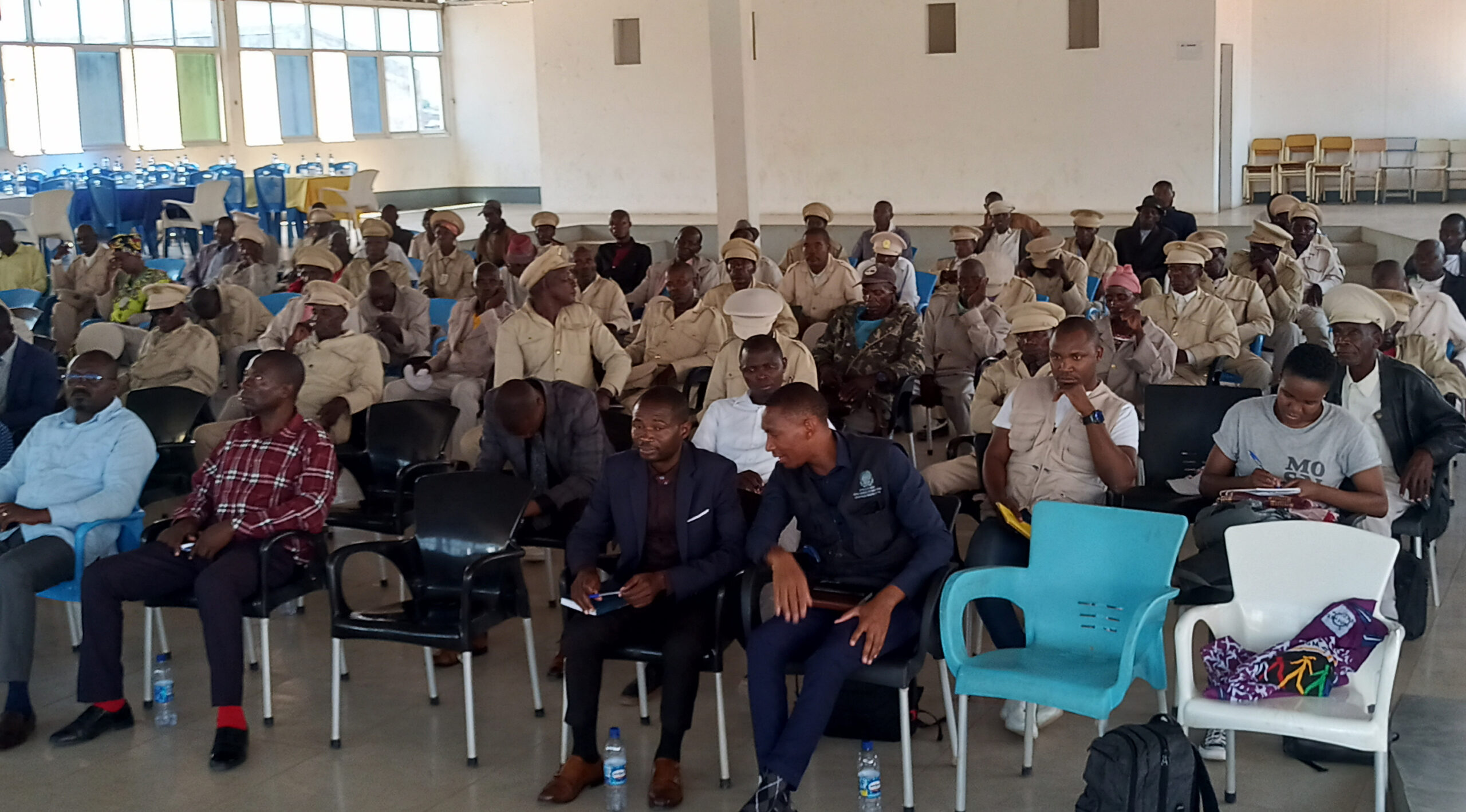 An audience in a conference room. Many are wearing police uniforms.