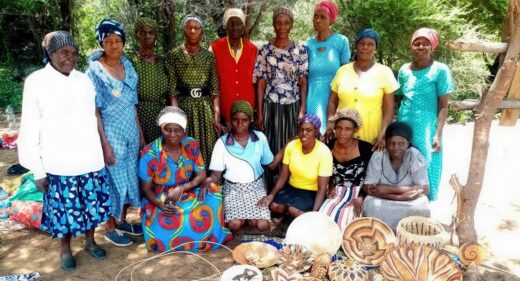 Fourteen ladies post with a collection of hand-woven baskets.